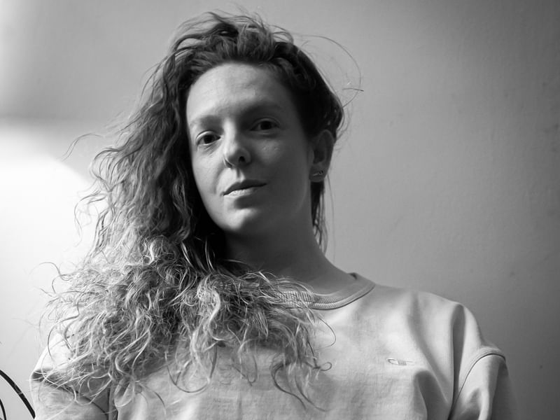 Black and white portrait of Jess looking into the camera.